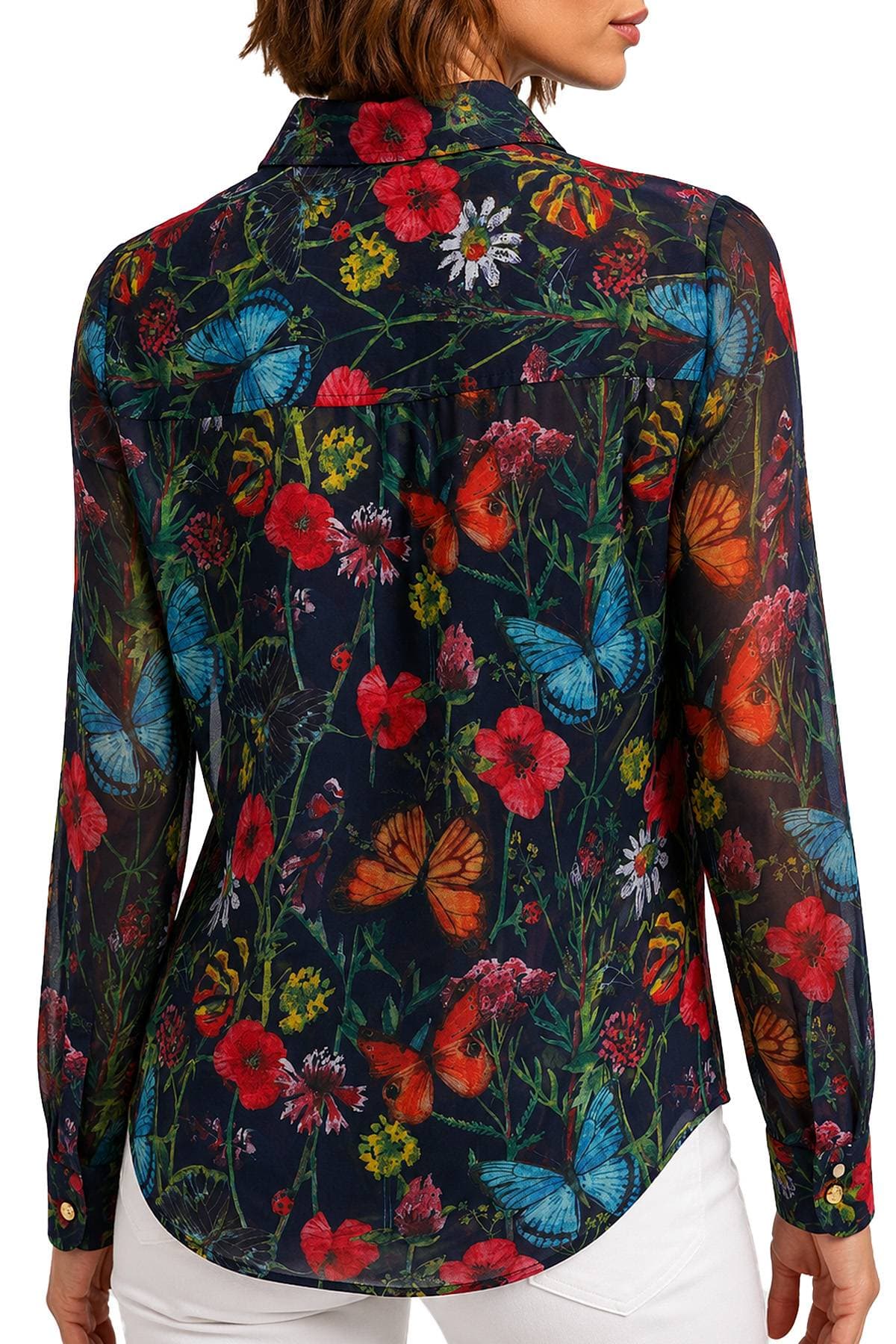 A person is wearing a sheer blouse with a vibrant floral and butterfly print.