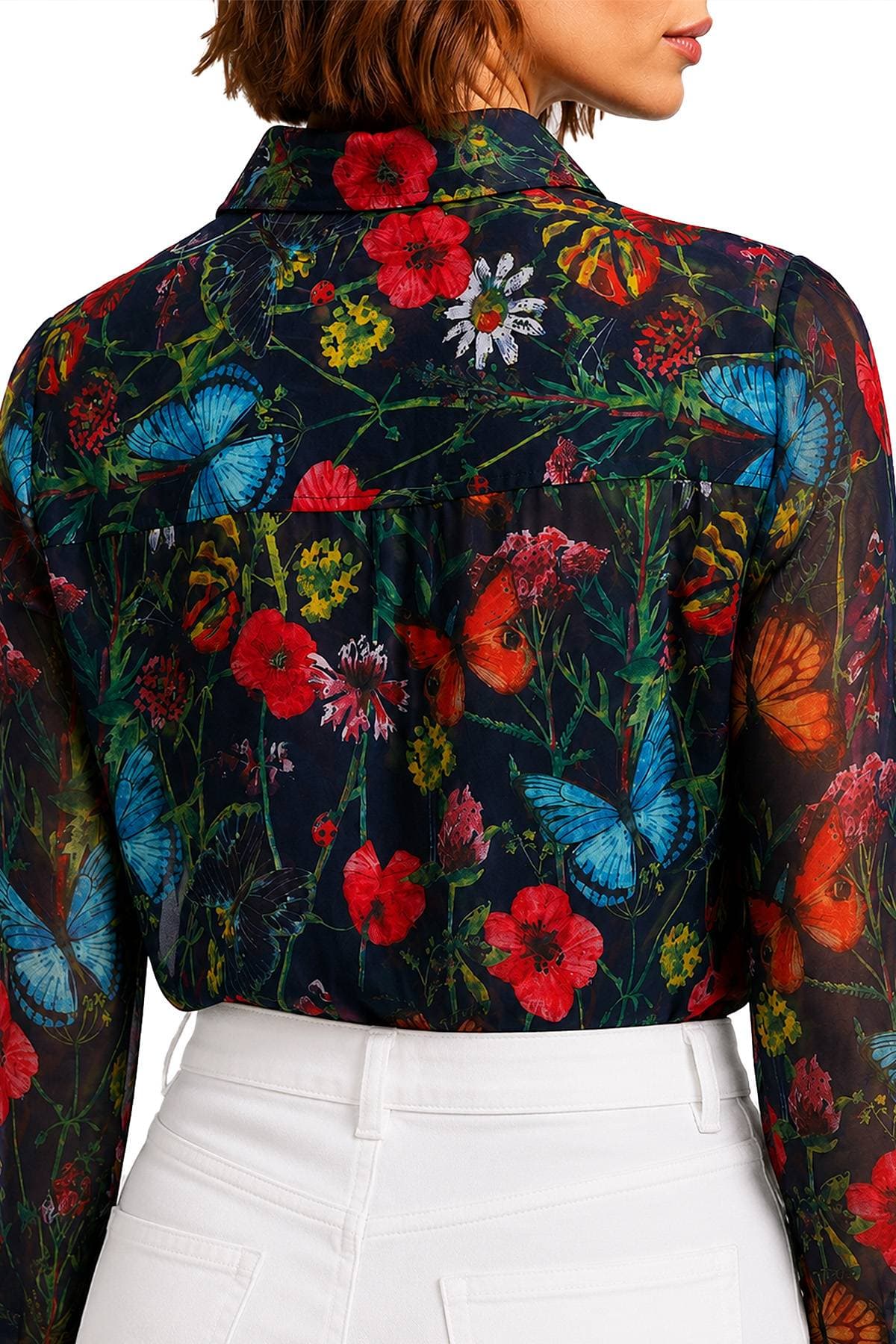 A person is wearing a floral and butterfly patterned shirt paired with white pants.
