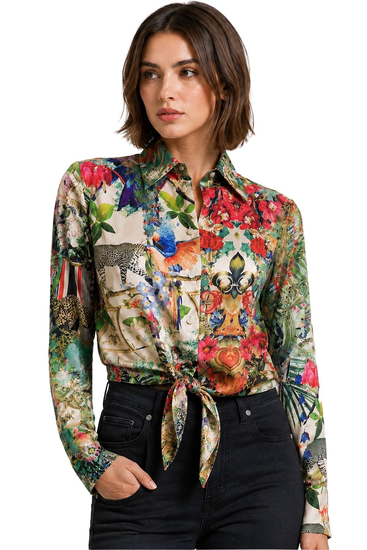 A person wearing a colorful button-up shirt with a detailed floral and animal print design, tied at the waist, paired with black pants.