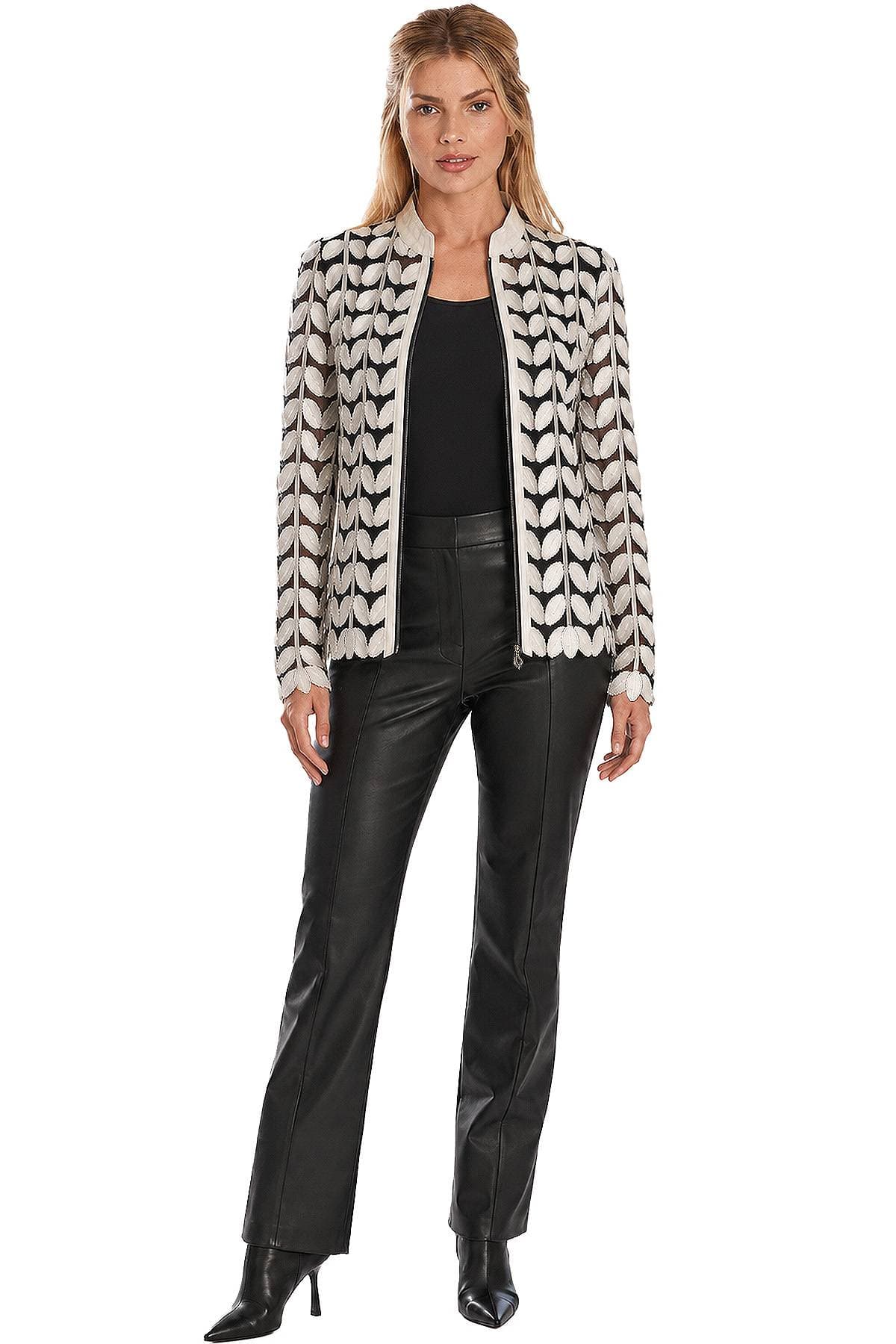 A woman is wearing a patterned jacket with a black top and black leather pants.