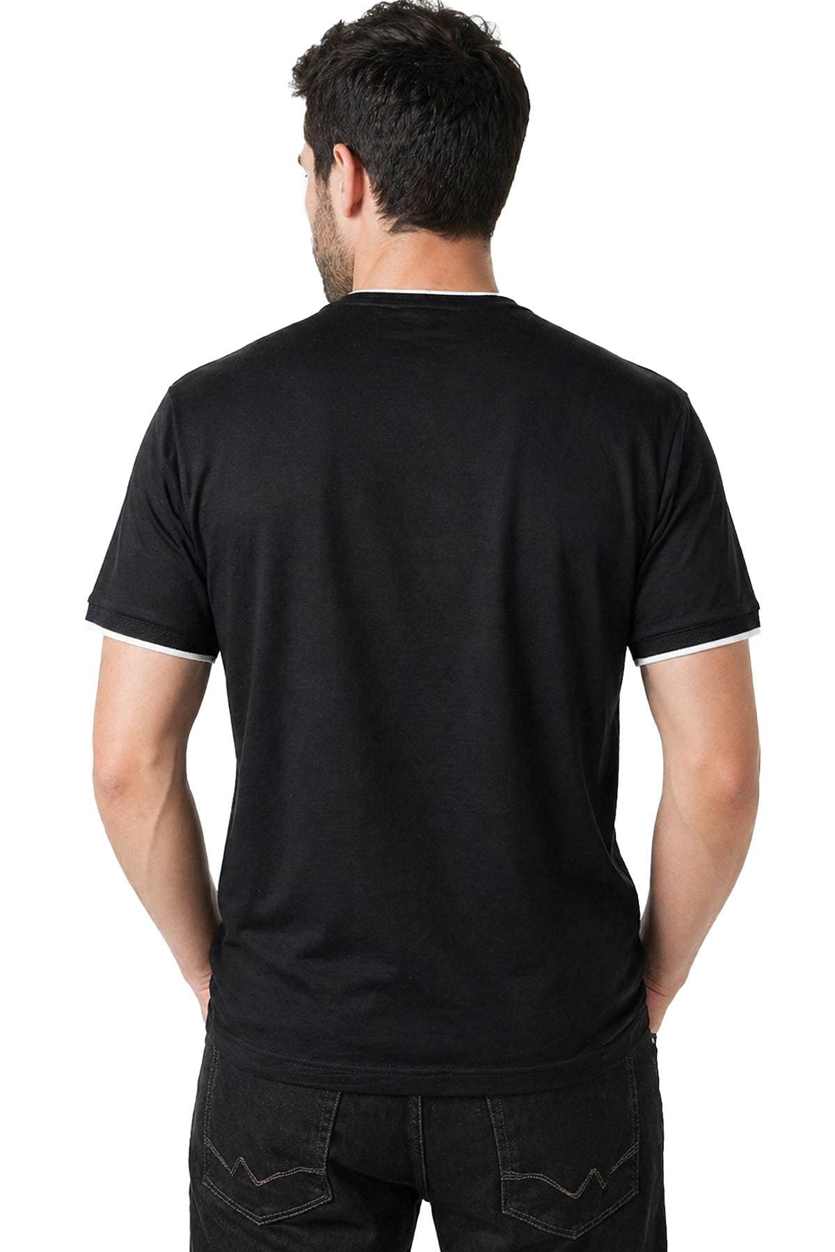 A man stands facing away, wearing a black t-shirt and jeans.