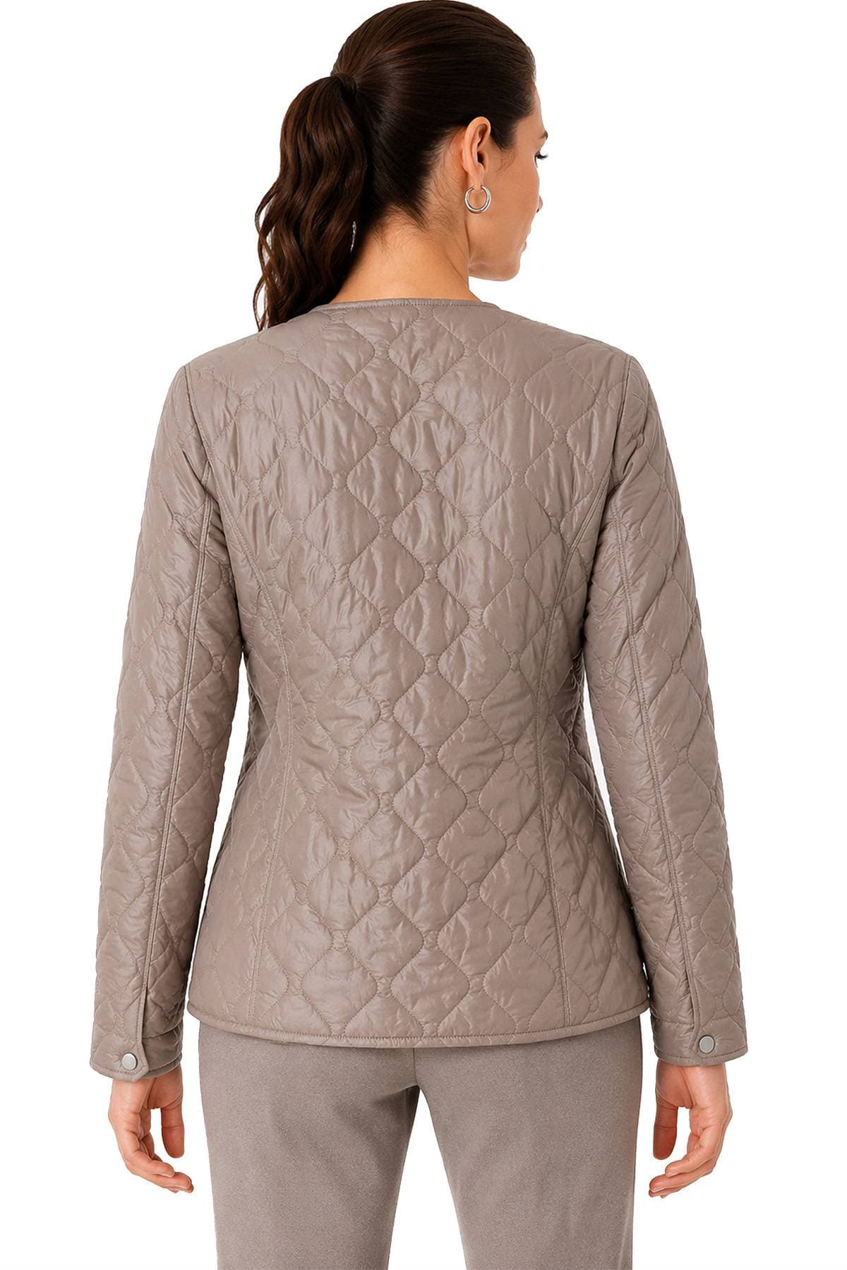 A person with a ponytail is wearing a light brown quilted jacket and matching pants, viewed from behind.