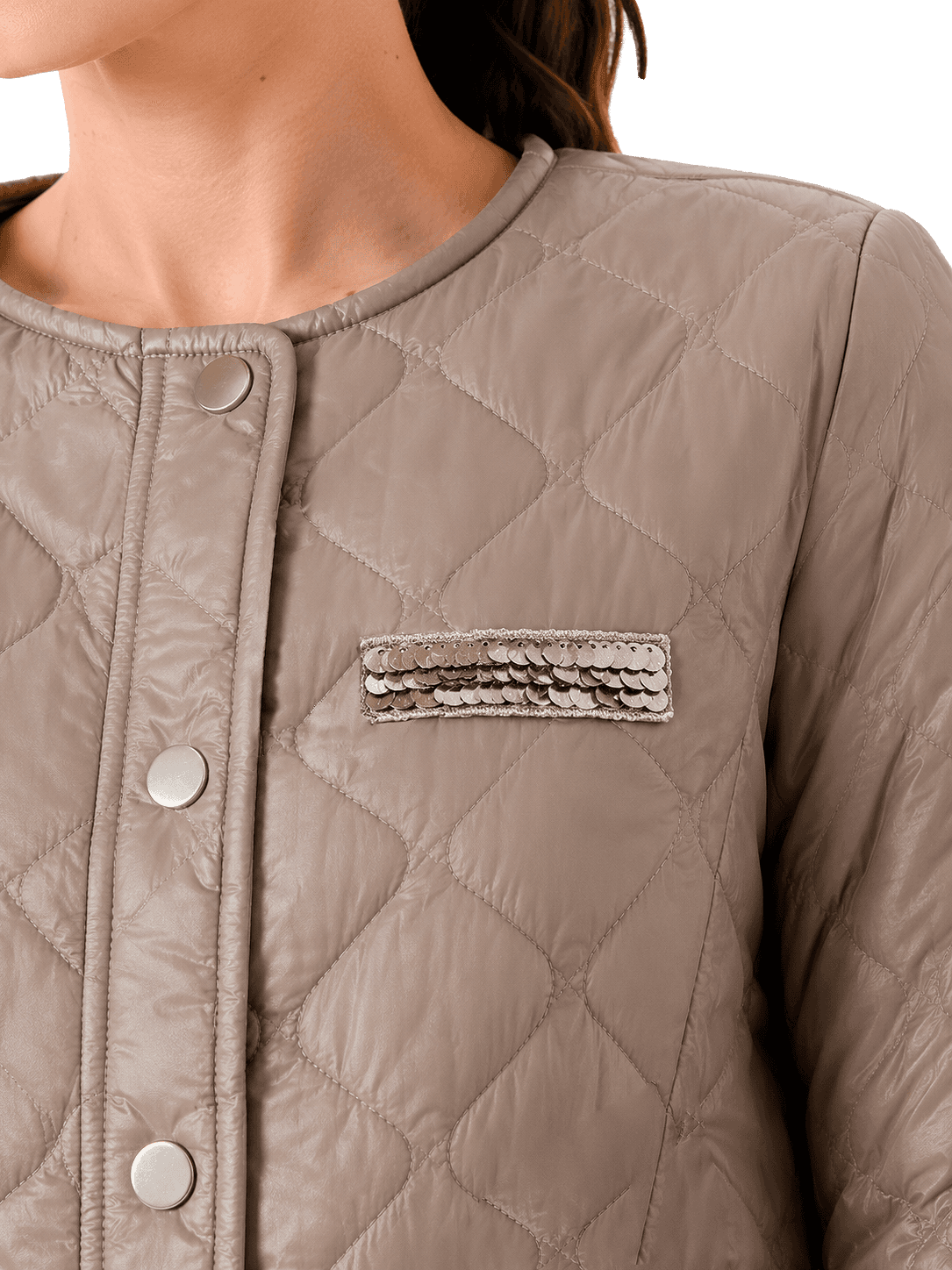 A close-up of a quilted jacket with metallic buttons and a sequin-embellished pocket detail.