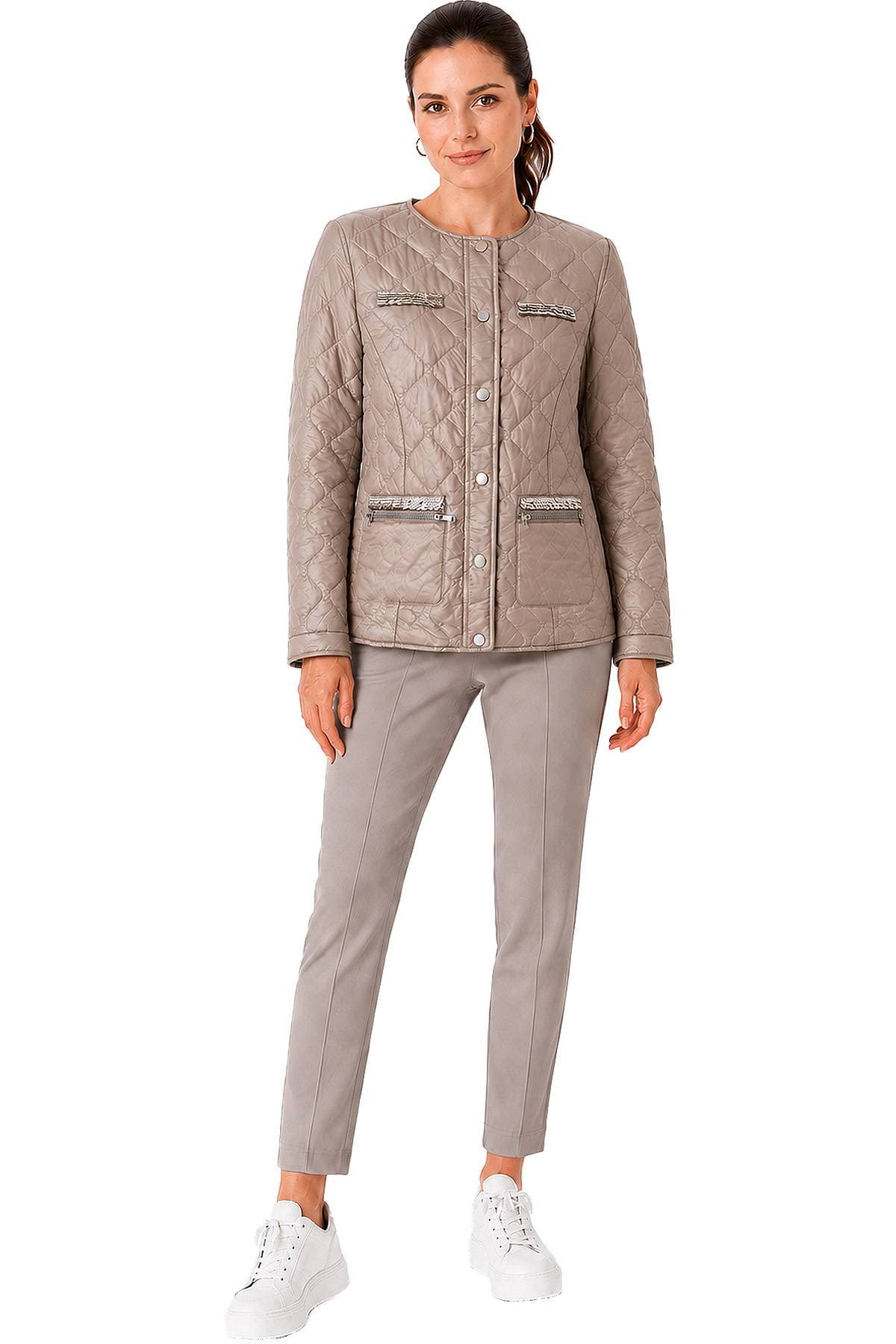 A person is wearing a quilted taupe jacket with decorative zippers, taupe pants, and white platform sneakers.
