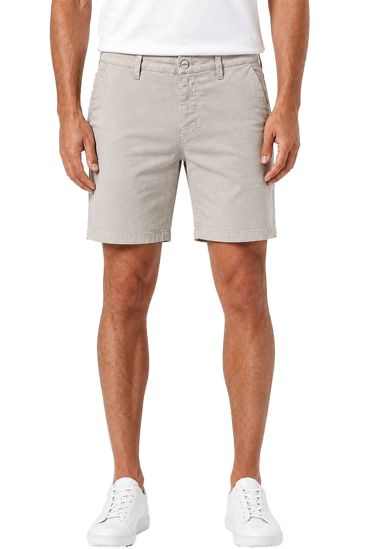 A person is wearing beige shorts with side pockets, a white t-shirt, and white sneakers.