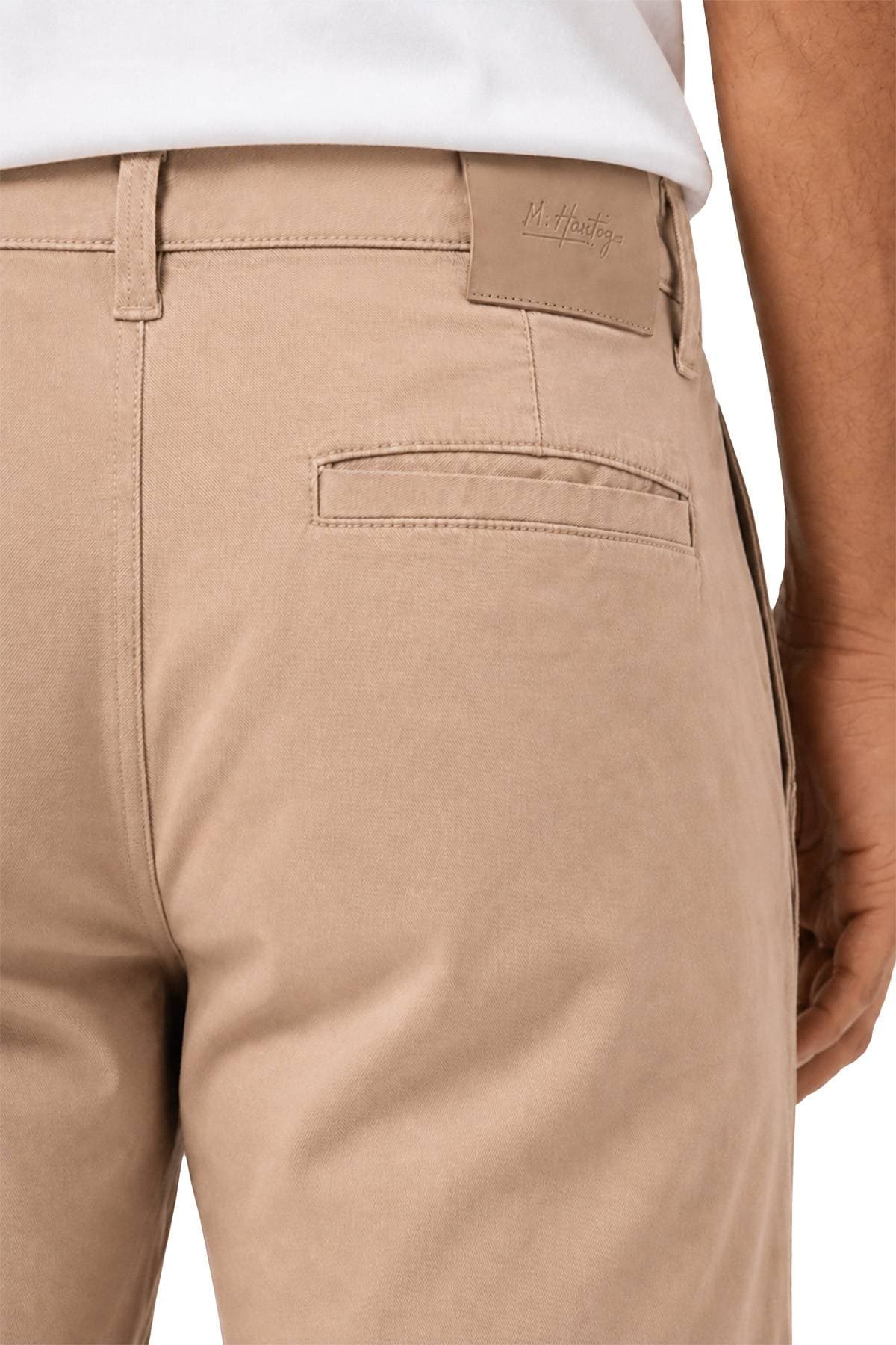 Close-up of beige trousers with a visible back pocket and belt loop.