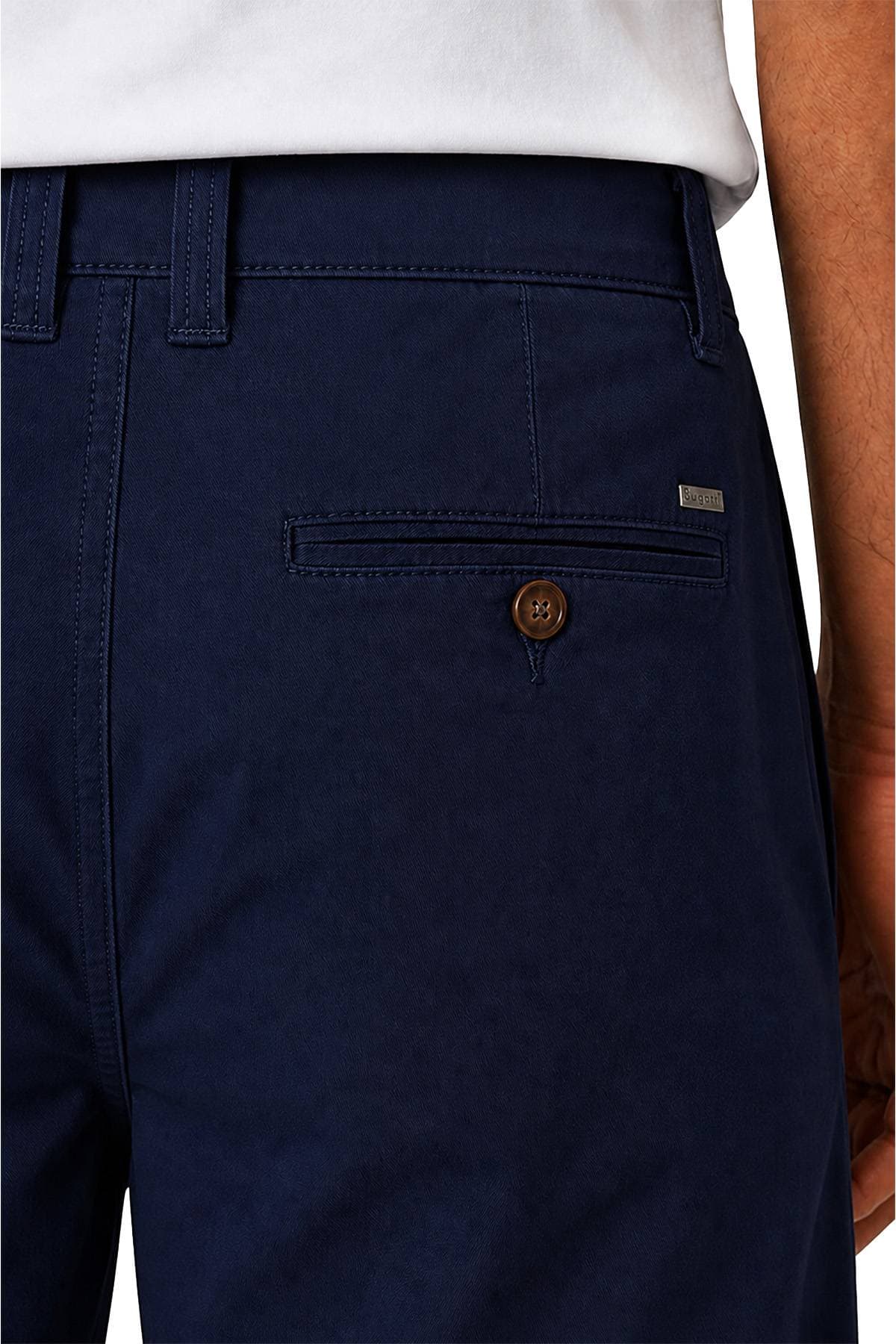 Close-up of dark blue pants with a single back pocket and button detail.