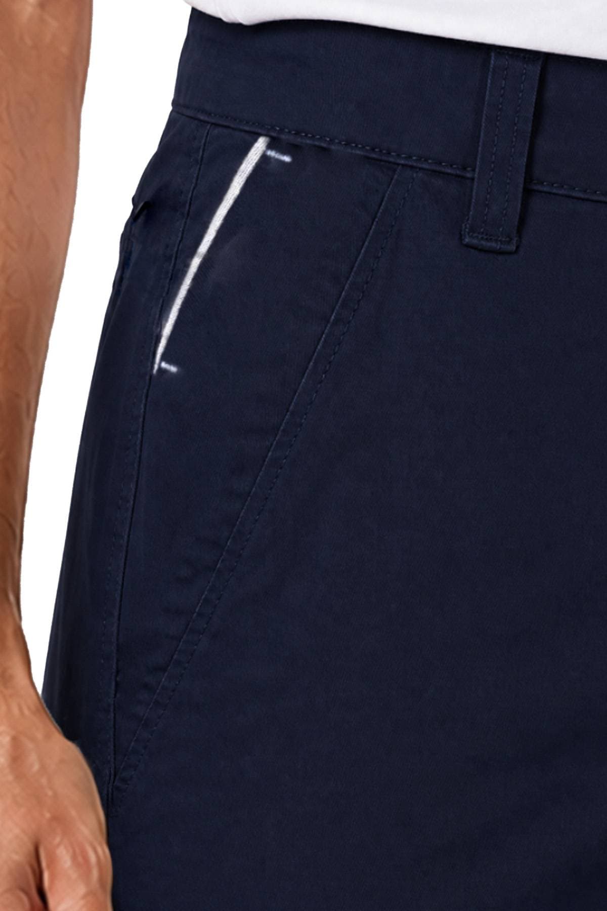 Close-up of a person's hand near the pocket of navy blue pants.