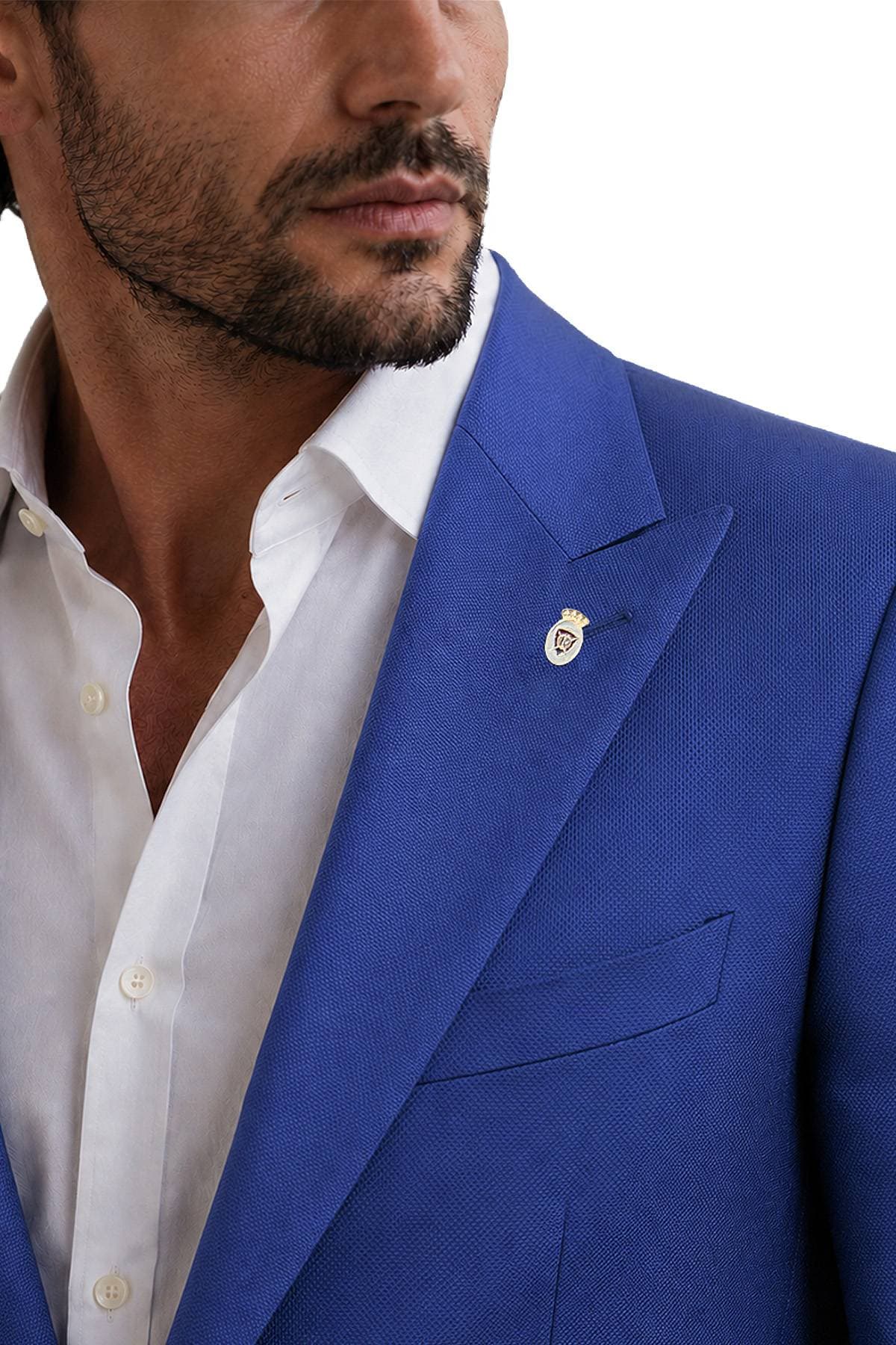 A man wearing a blue suit with a white shirt and a pin on the lapel.