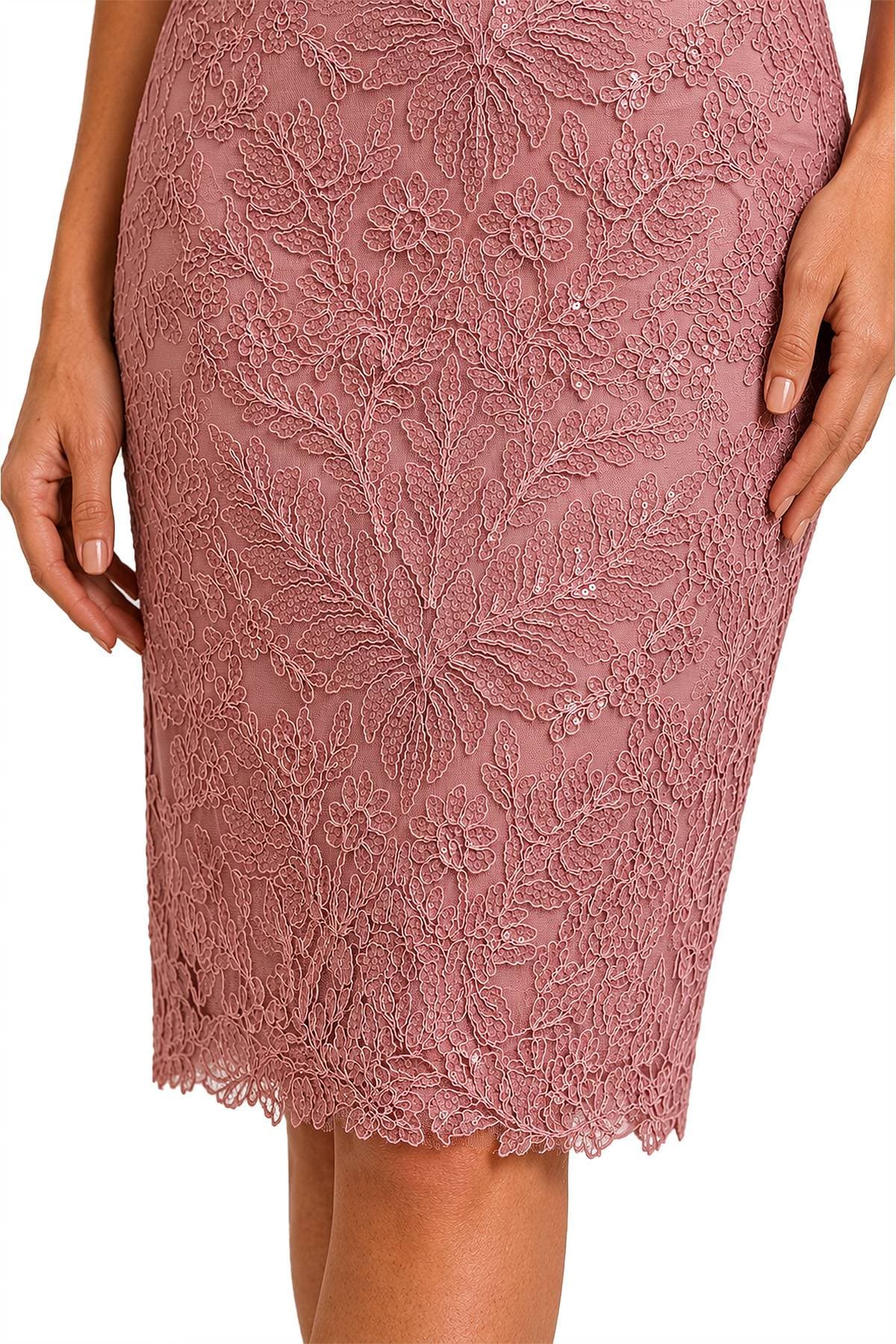 A close-up of a person wearing a pink lace pencil skirt with floral patterns.