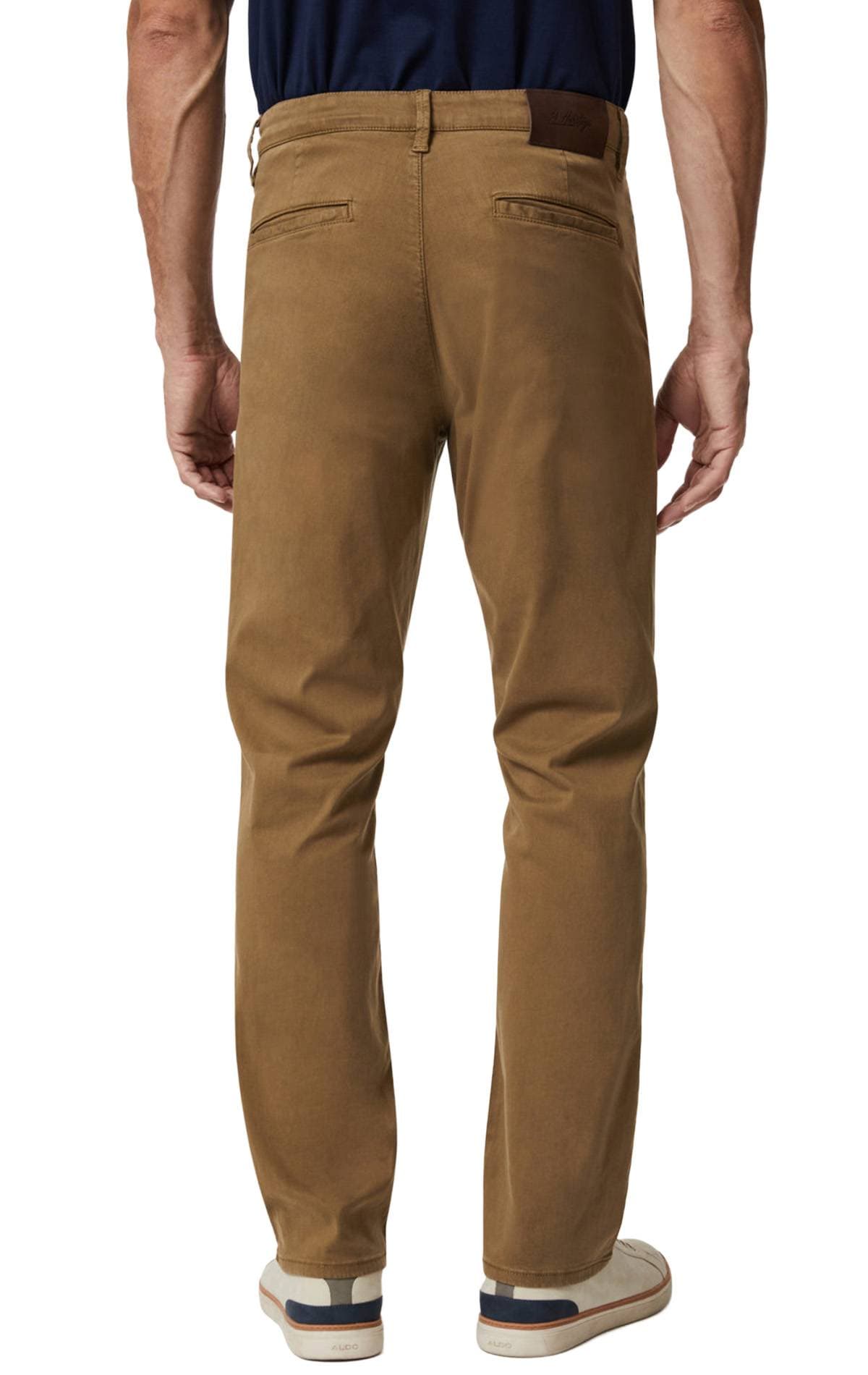 A person wearing tan chinos and white sneakers is shown from the back.