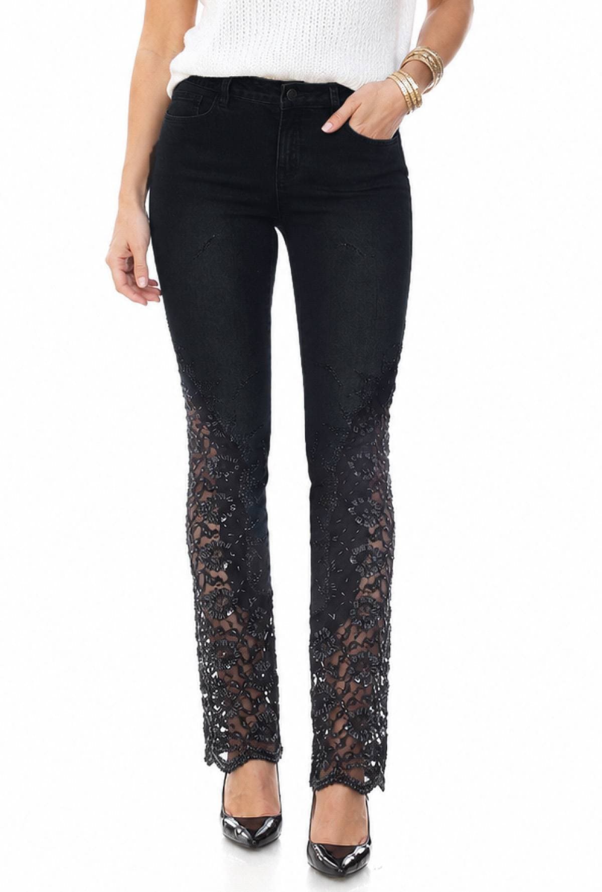 A person wearing black lace overlay pants and black high heels.