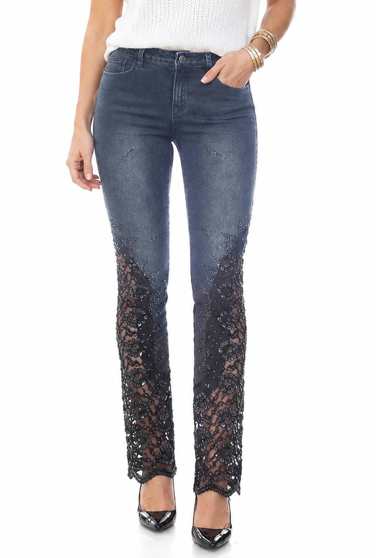 A person wearing dark jeans with intricate lace detailing from the knee down, paired with black high heels.
