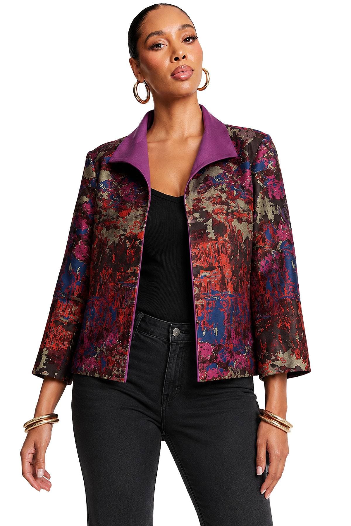 A woman wearing a colorful, abstract-patterned jacket with a purple collar.