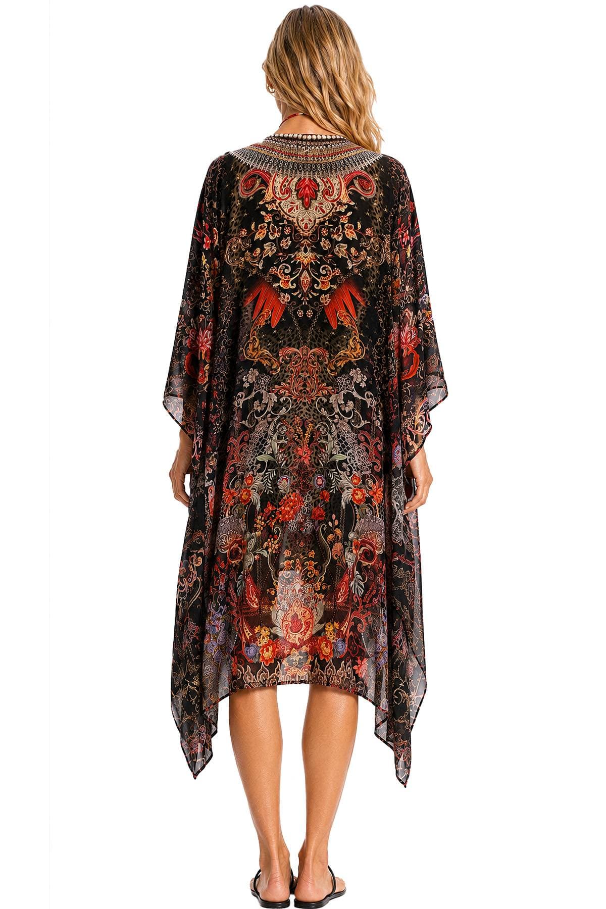 A person wearing a long, intricately patterned kaftan with floral and abstract designs viewed from the back.