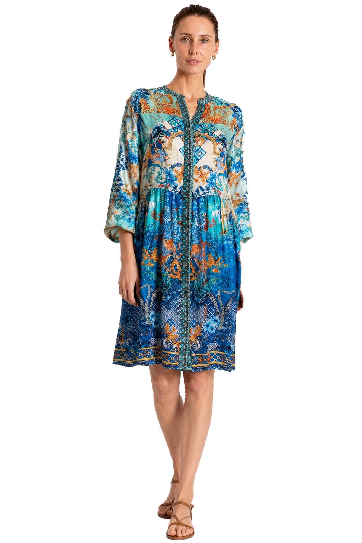 A woman is wearing a colorful, patterned dress with a mix of blue and orange tones.