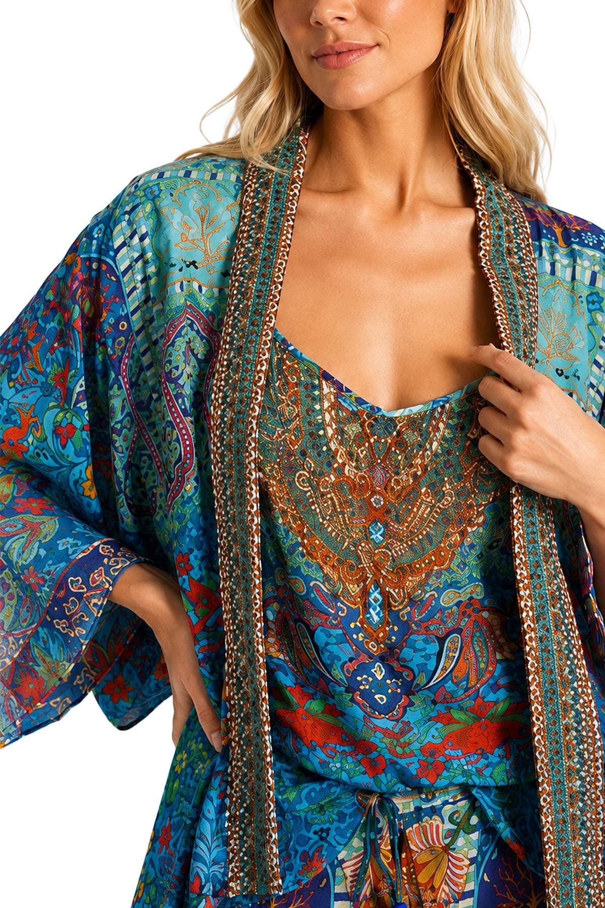 A person wearing a vibrantly patterned blue and orange garment with intricate designs.