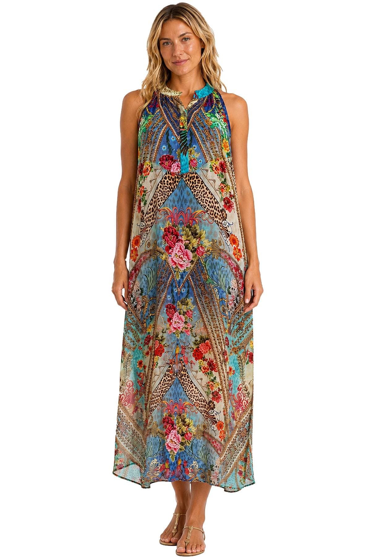 A woman is wearing a colorful, patterned maxi dress and sandals.