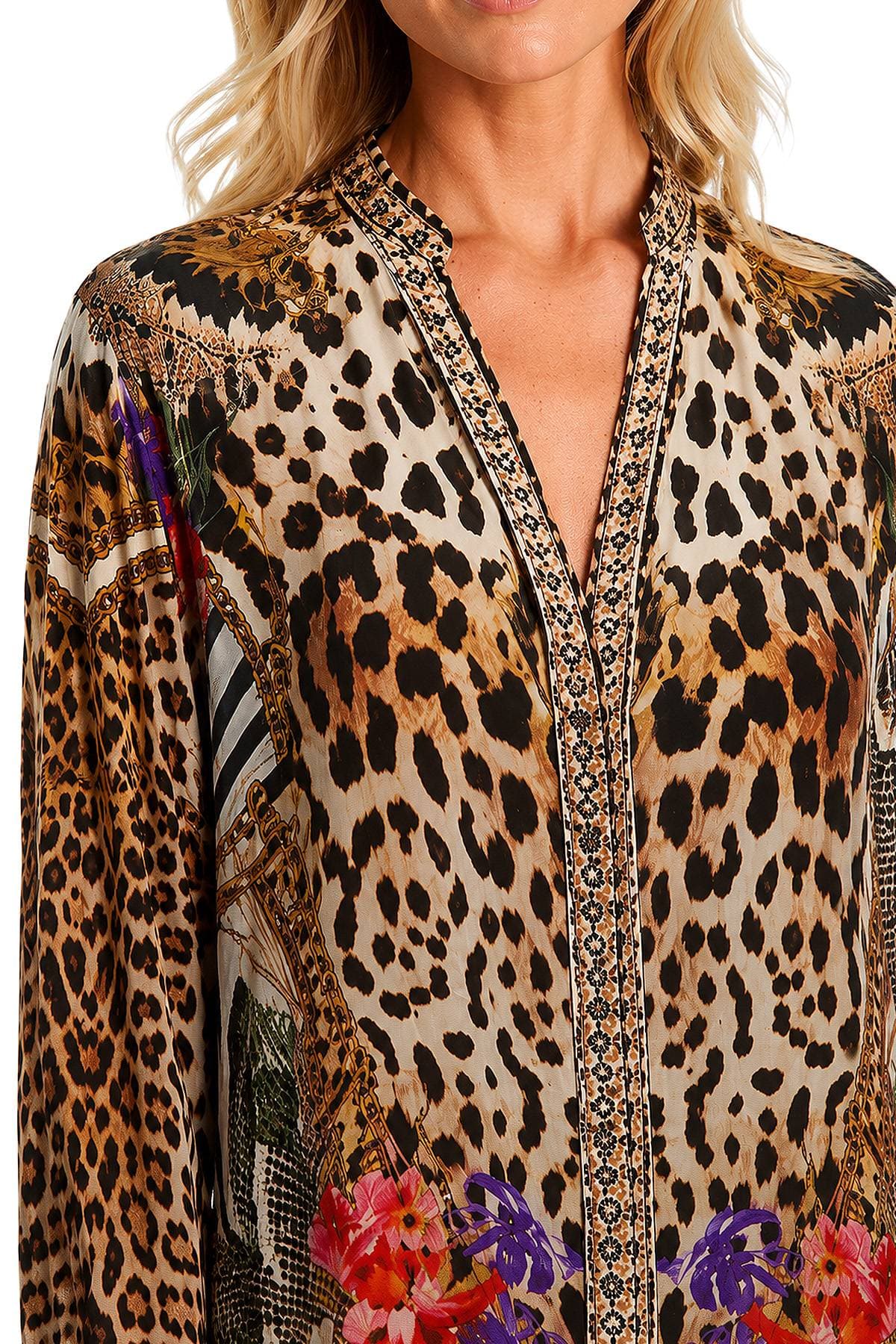 A woman wears a leopard print blouse with intricate floral and geometric designs.