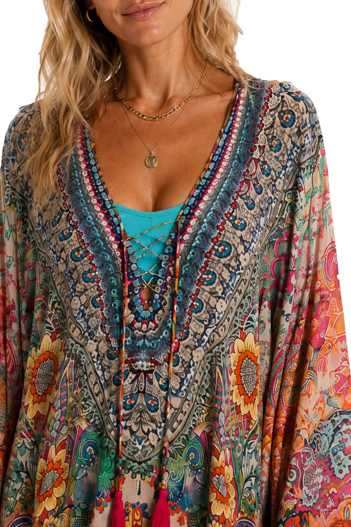 A person wearing a colorful, intricately patterned dress with floral designs and beading, and layered necklaces.