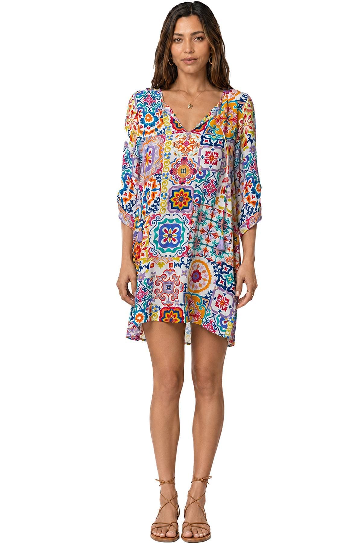 A woman is wearing a brightly patterned dress with a colorful mosaic design.
