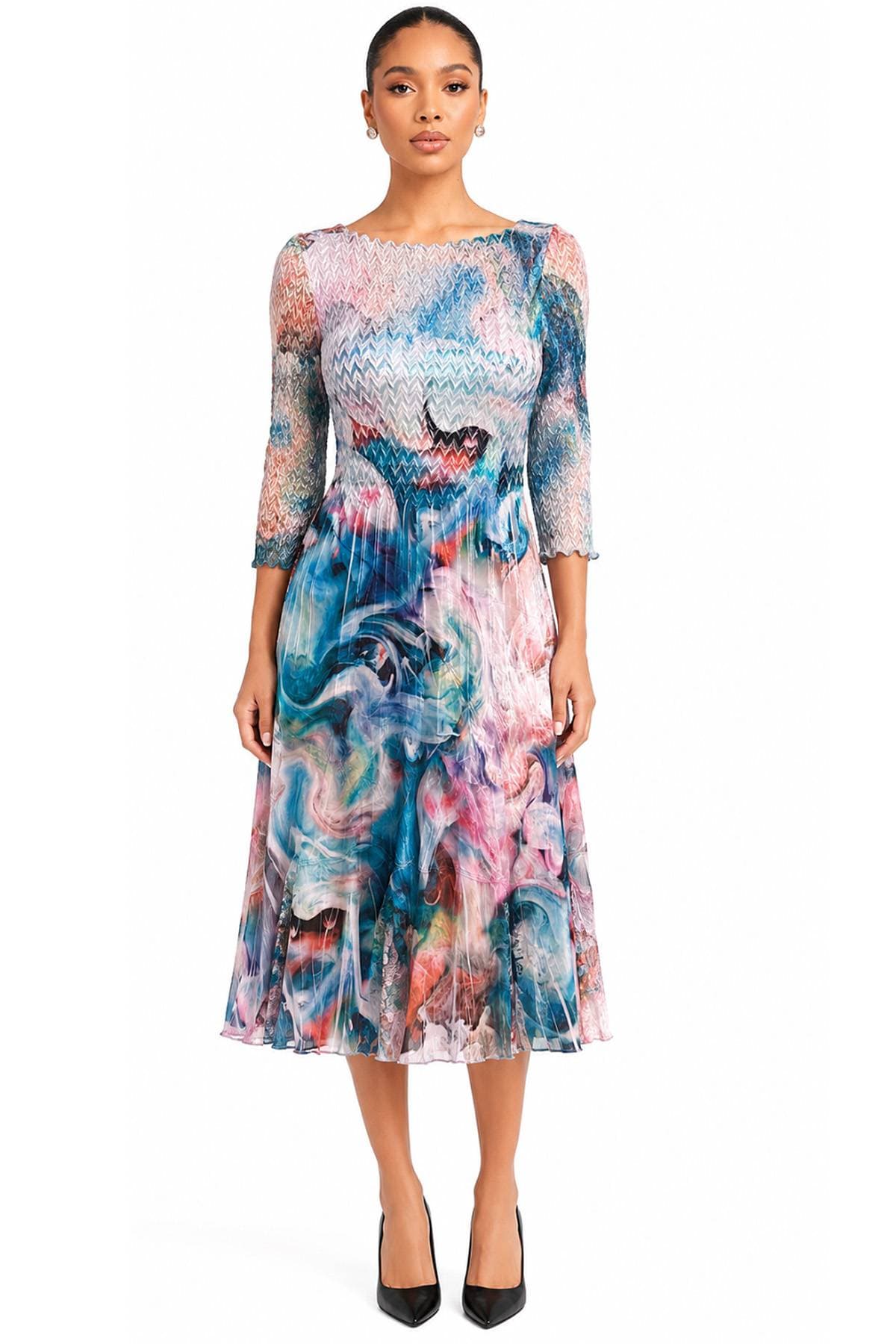 A woman is wearing a colorful, long-sleeved, knee-length dress with a swirling abstract pattern and black heels.