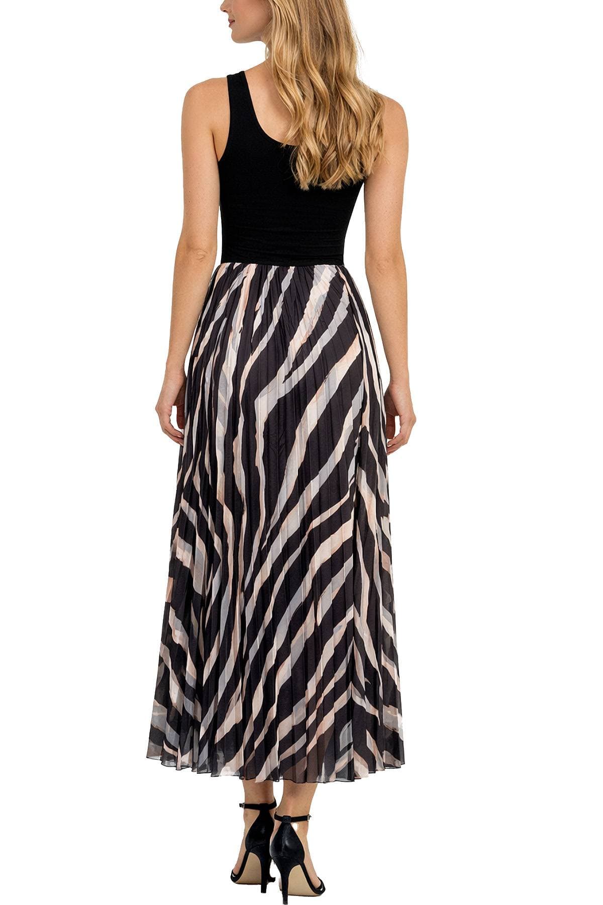 A person wearing a black sleeveless top and a pleated striped skirt with black high heels.