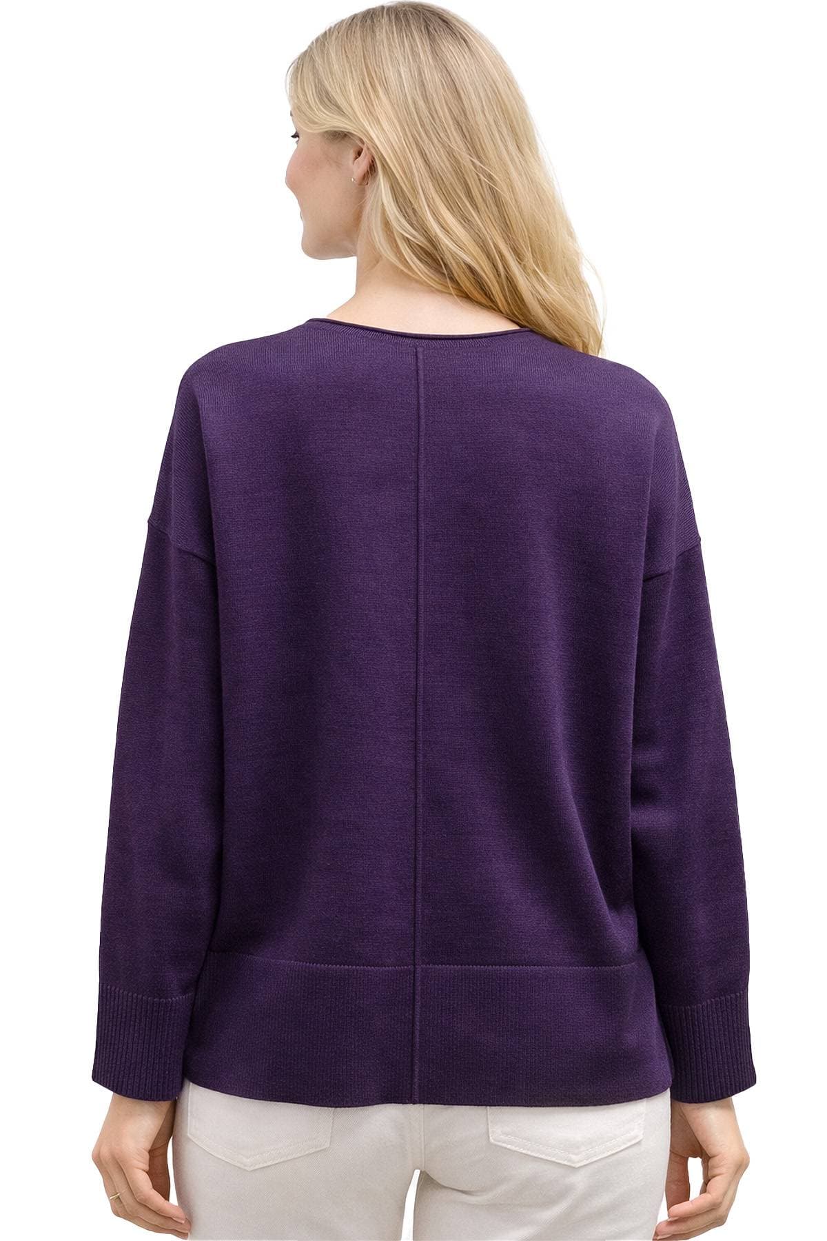 A person with long blonde hair is wearing a dark purple sweater viewed from behind.