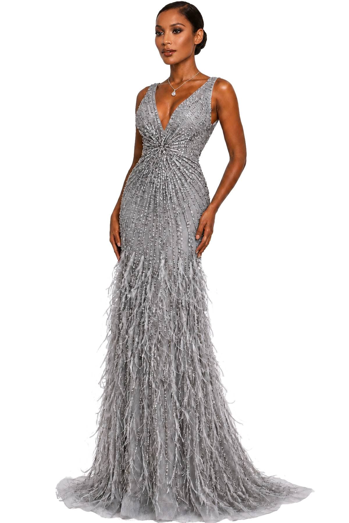 A woman wearing a sleeveless silver gown with intricate beadwork and feather details.