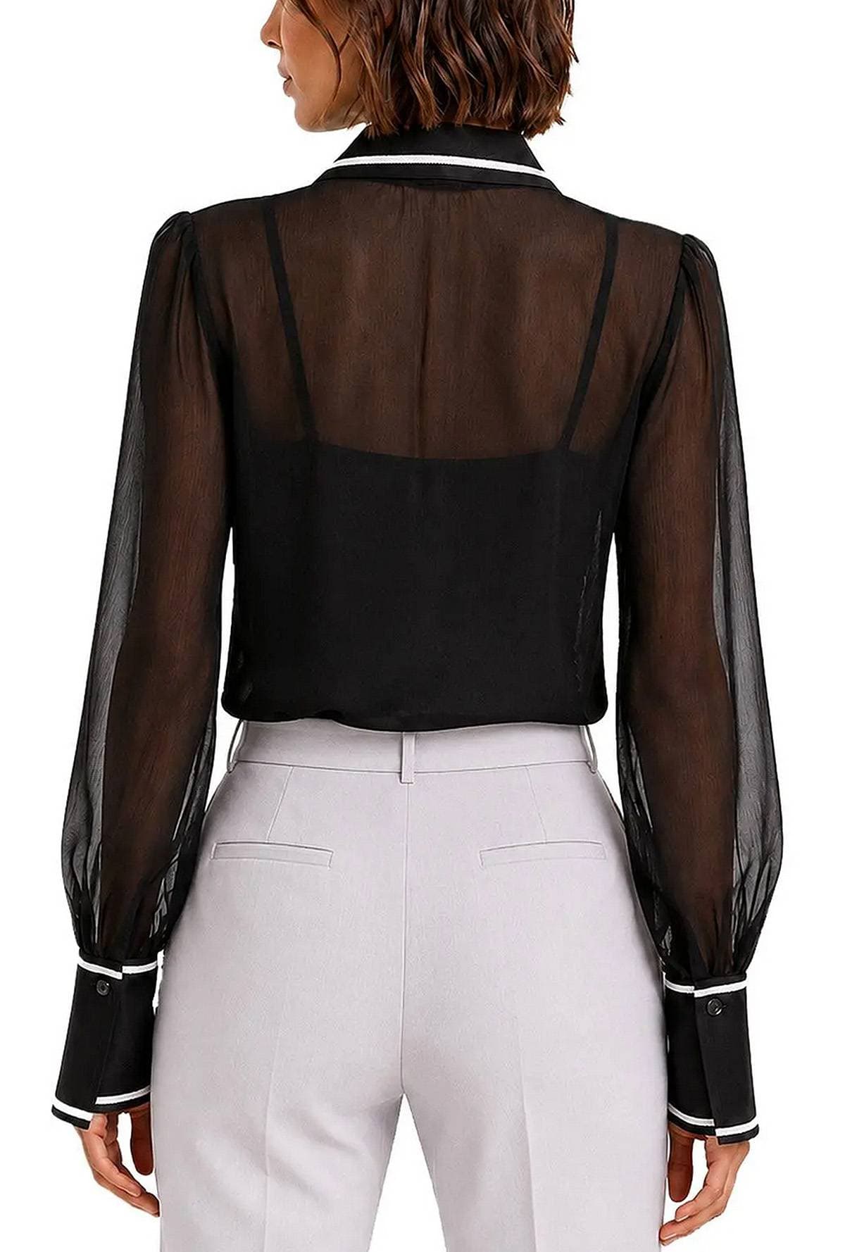A person wearing a sheer black blouse with long sleeves and white pants is shown from the back.