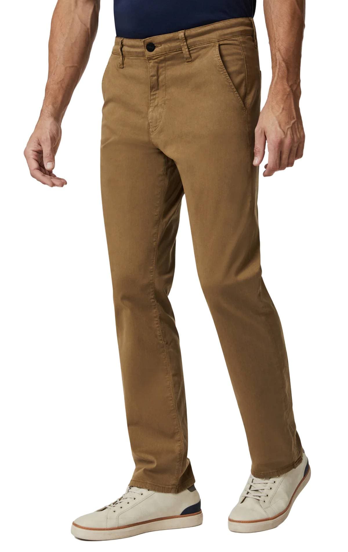 A person wearing brown pants and white sneakers with blue accents.