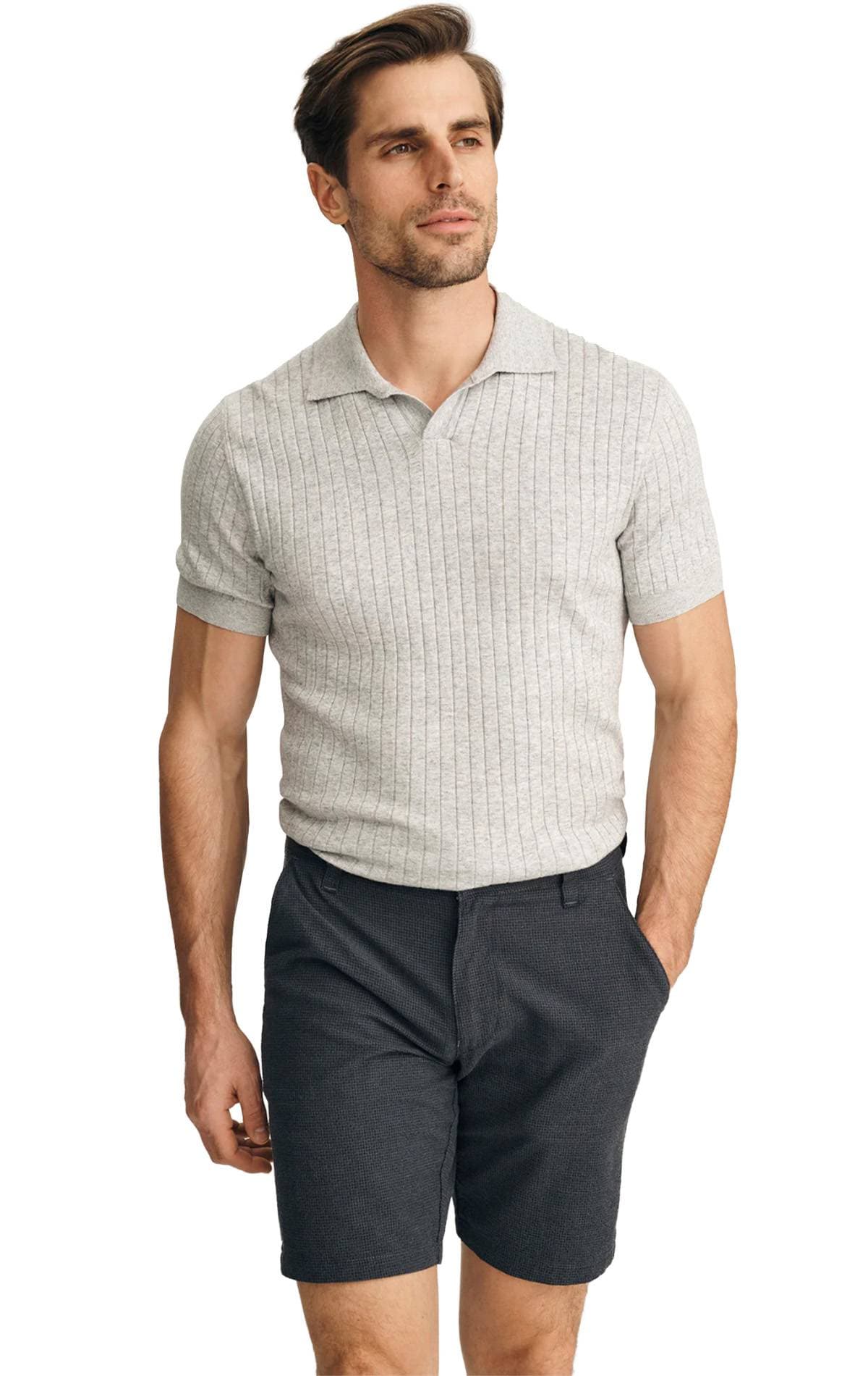 A man wearing a light gray short-sleeve polo shirt and dark shorts.